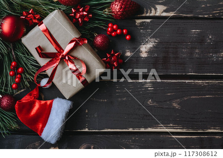 Christmass background gift boxe,red christmas tree toys,Santa hatn and spruce brance on wooden background. 117308612