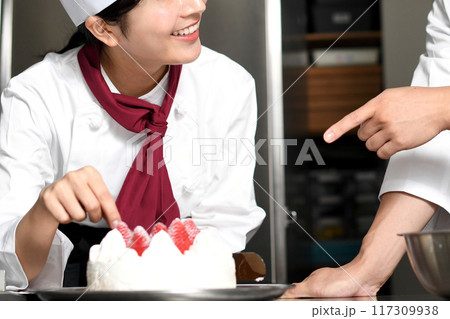 ケーキ作りする女性パティシエと教える男性 ケーキ作りする女性パティシエと教える男性 117309938