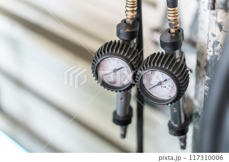 自動車整備工場の壁にかかってるタイヤ空気圧ゲージ 117310006