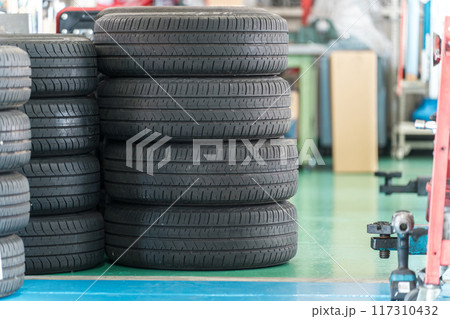 自動車整備工場に置かれたホイール付きタイヤ 117310432