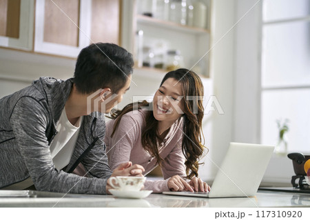 young asian couple using laptop computer together at home 117310920