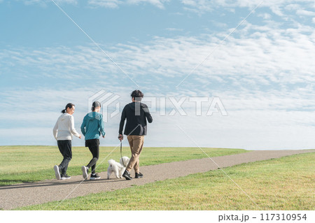 青空の見える公園で犬の散歩・運動・トレーニング・有酸素運動をするさわやかな家族・親子 青空の見える公園で犬の散歩・運動・トレーニング・有酸素運動をするさわやかな家族・親子 117310954
