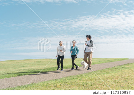 青空の見える公園で犬の散歩・運動・トレーニング・有酸素運動をするさわやかな家族・親子 青空の見える公園で犬の散歩・運動・トレーニング・有酸素運動をするさわやかな家族・親子 117310957