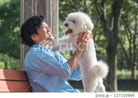 犬の散歩をする愛犬家の中高年男性・ドッグセラピー（抱く・抱っこ） 117310999