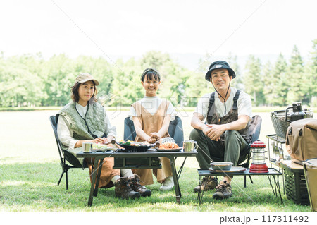 公園・キャンプ場でデイキャンプ・キャンプ・バーベキューを楽しむ仲良しのファミリー 117311492