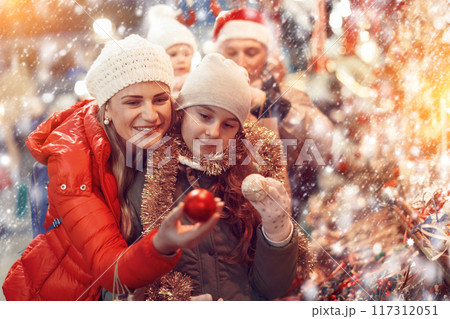 Woman with daughter choosing Christmas toys 117312051