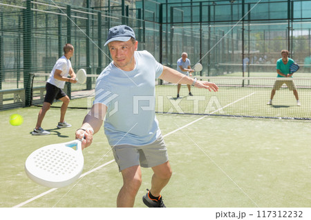 Adult and young men playing padel against two men 117312232