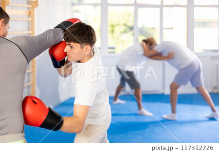 Two men training boxing fight in studio Two men training boxing fight in studio 117312726