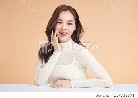 Beautiful young asian woman with clean fresh skin on beige background, Face care, Facial treatment, Cosmetology, beauty and spa, Asian women portrait. Beautiful young asian woman with clean fresh skin on beige background, Face care, Facial treatment, Cosmetology, beauty and spa, Asian women portrait. 117315871