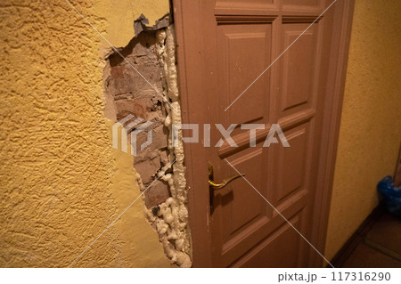 Exposed wall with insulation visible alongside a brown door 117316290