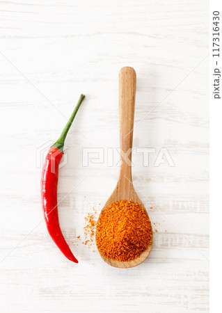 red chilie and ground chilies on white wooden table. 117316430