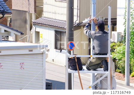 外灯に防犯カメラを取り付ける男性 外灯に防犯カメラを取り付ける男性 117316749