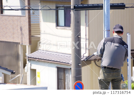 外灯に防犯カメラを取り付ける男性 外灯に防犯カメラを取り付ける男性 117316754