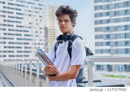 Portrait young male college student with backpack textbooks copybooks, outdoor Portrait young male college student with backpack textbooks copybooks, outdoor 117317692