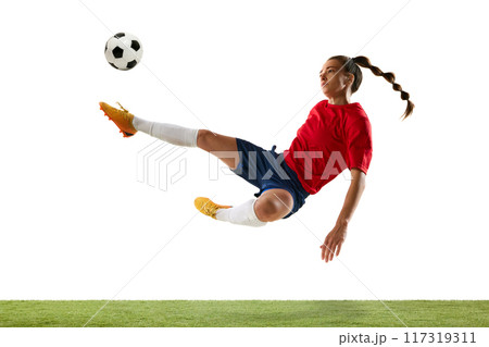 Aerial soccer stunt. Female player delivers impressive bicycle kick, aiming to opponents gates, showing energy of game. Aerial soccer stunt. Female player delivers impressive bicycle kick, aiming to opponents gates, showing energy of game. 117319311