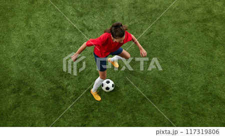 Aerial view of female football athlete training dribbling technique on green lush stadium. Workout for win. 117319806