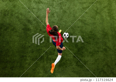 Focused on game female soccer player passing ball in motion during training session on green lash stadium. Focused on game female soccer player passing ball in motion during training session on green lash stadium. 117319824