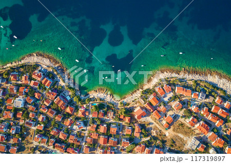 Aerial top view of seashore with turquose water and coastal city with red-roofed houses. Panorama of tourist town Rogoznica in Croatia on Adriatic Sea. Summer vacation and travel concept 117319897