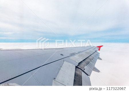 View from the airplane window at a beautiful cloudy sky and the airplane wing View from the airplane window at a beautiful cloudy sky and the airplane wing 117322067