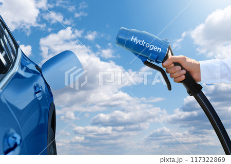 Man holds a hydrogen fueling nozzle. Refueling car with hydrogen fuel 117322869