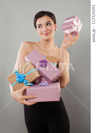 Gorgeous positive young adult model woman posing showing pink and beige present gift box Gorgeous positive young adult model woman posing showing pink and beige present gift box 117324201