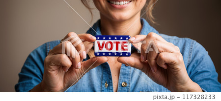 Woman smiling and showing vote badge with copy space 117328233