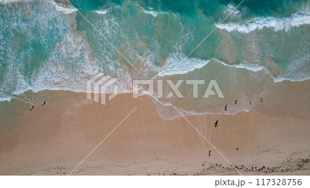 A breathtaking aerial view of a pristine beach in the Dominican Republic, featuring turquoise waves crashing onto soft golden sands. 117328756