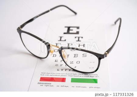 Glasses on eye testing exam chart to check eyesight accuracy of reading. 117331326