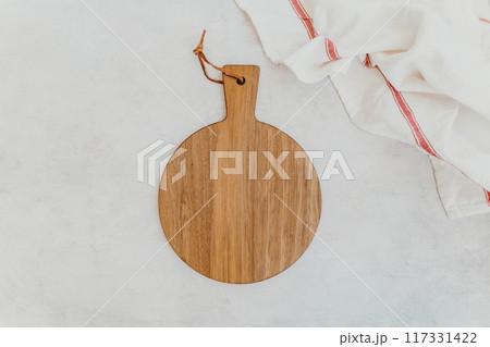 Empty wooden cutting board with napkin on gray stone table 117331422