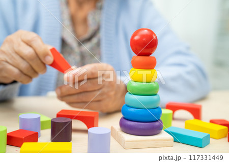 Alzheimer disease AD, Asian elderly woman patient suffering from dementia learn practical motor skills rehabilitation. 117331449