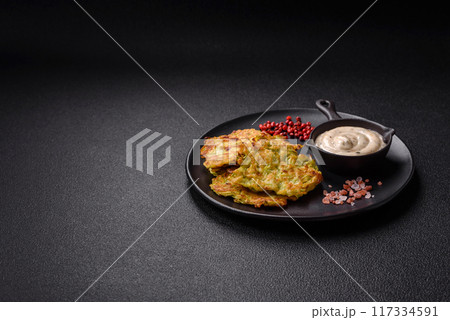 Vegetable zucchini fritters with garlic, salt, spices and herbs 117334591