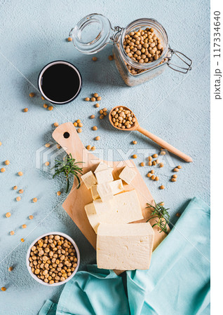 Organic vegetarian soy tofu and rosemary on wooden board on table top and vertical view Organic vegetarian soy tofu and rosemary on wooden board on table top and vertical view 117334640