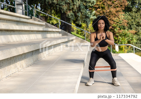 Woman exercising outdoors and looking concentrated and focused 117334792