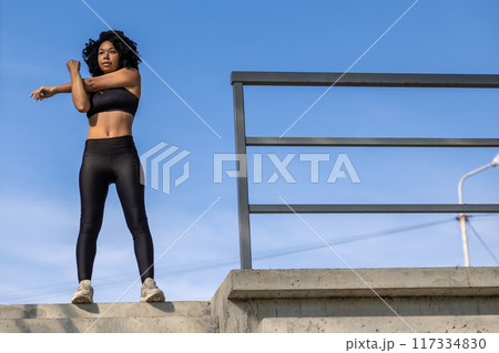 Slim fit black-haired woman stretching in the fresh air 117334830
