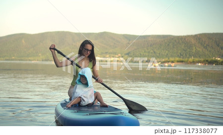 Embark on a Serene Paddleboarding Adventure on a Beautifully Calm Lake, Embracing Nature Embark on a Serene Paddleboarding Adventure on a Beautifully Calm Lake, Embracing Nature 117338077