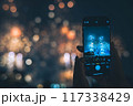 スマートフォンの画面越しで見る花火 117338429