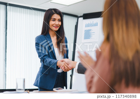 Successful business people shaking hands during a meeting in the office. 117340898