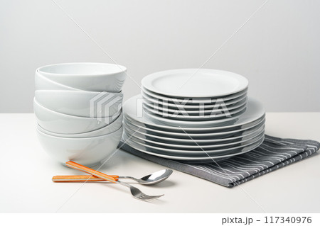 Stylish table setting with white dishware on white tablecloth Stylish table setting with white dishware on white tablecloth 117340976