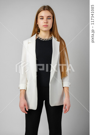 Woman in Black Top and White Jacket Posing in Studio 117341085