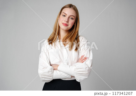 Joyful Young Blonde Woman Smiling against gray background Joyful Young Blonde Woman Smiling against gray background 117341207