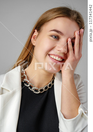 Woman Smiling and Holding Hand to Face Woman Smiling and Holding Hand to Face 117341442