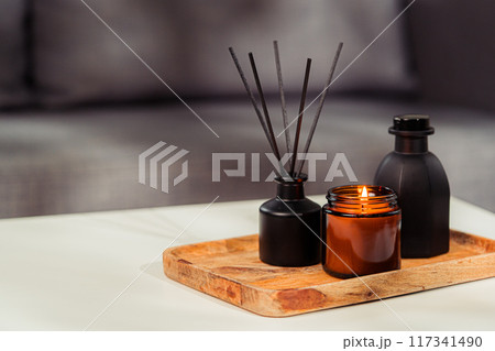 Aromatic reed freshener and candle on table in room Aromatic reed freshener and candle on table in room 117341490