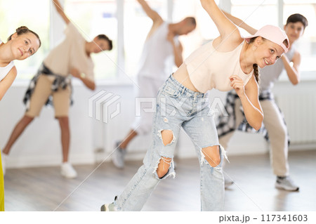 Group of girls an boys perform choreographic exercises and teaches energetic breakdancing waacking together 117341603
