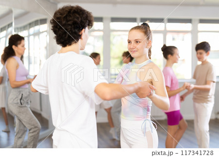 Girl dances waltz with male boy teen partner during choreography lesson 117341728