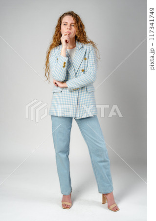 Thoughtful Young Woman Against Grey Background in Studio 117341749