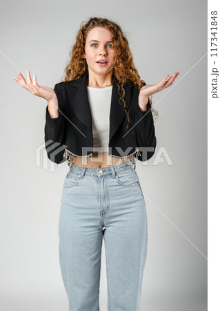 Young Curly Clueless Woman Holding Out Hands 117341848