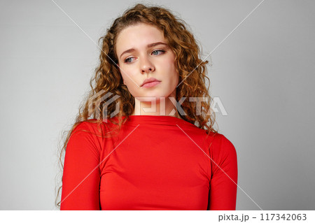 Young Woman With Curly Hair Expressing Concern 117342063