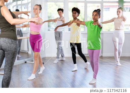 Group of teenage dancers training ballet in studio Group of teenage dancers training ballet in studio 117342116