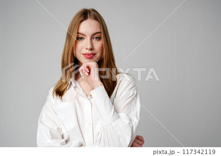 Joyful Young Blonde Woman Smiling against gray background Joyful Young Blonde Woman Smiling against gray background 117342119
