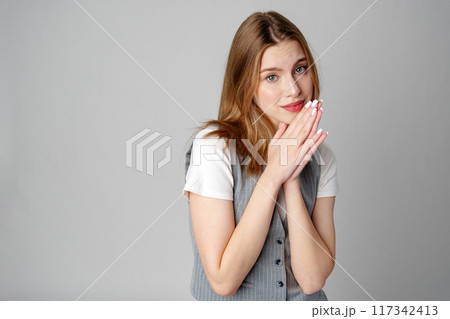 Joyful Young Blonde Woman Smiling against gray background Joyful Young Blonde Woman Smiling against gray background 117342413